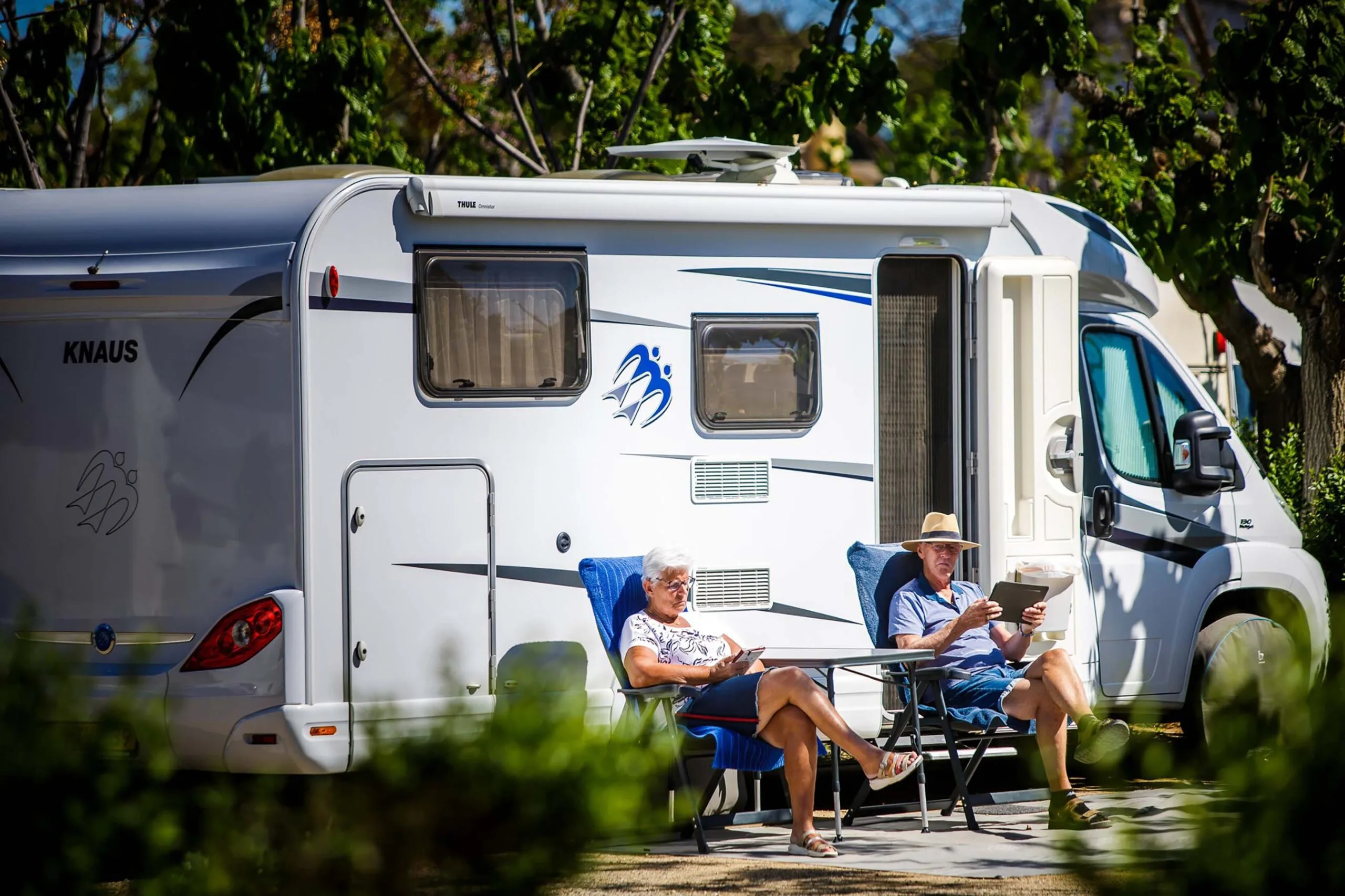 Retired couple in front of their camper van in Provence off-season — senior camping Europe